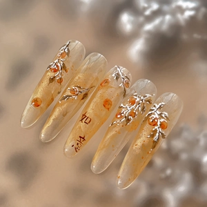Elegant 3D embossed persimmon nail art stiletto tips with gold glitter and Chinese charm
