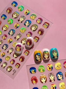 Macro view of holographic nail stickers featuring anime emoji designs on colorful nails