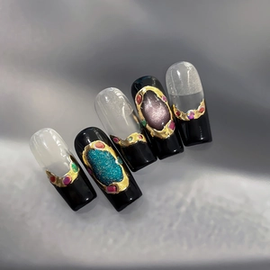 Faux ongles faits main noirs avec bordure métallique dorée et paillettes bleu-violet