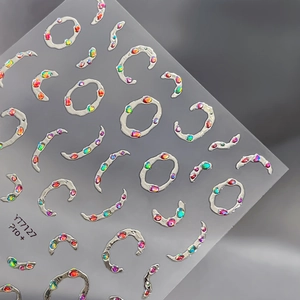 Autocollants 3D pour ongles avec anneaux argentés et strass irisés sur une planche