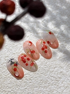 Macro shot of jelly pink gradient press-on nails with Chinese style red fruit patterns