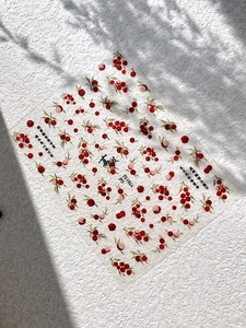 Macro detail of summer berry nail art stickers with green leaves and Chinese characters