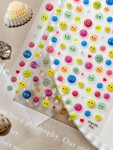 Macro detail of colorful 3D embossed eye nail art stickers on a decorative background