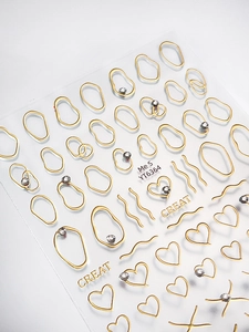 Detail of gold heart and geometric nail stickers with rhinestones on a white background
