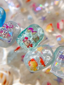Vue macro de breloques océaniques transparentes avec motifs marins et paillettes
