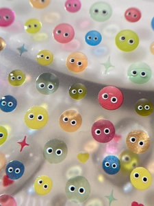 Macro shot of colorful 3D embossed jelly googly eyes stickers with glitter details