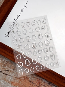 Macro detail of 3D silver nail stickers with heart circles and rhinestone embellishments