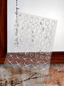 Detail of 3D silver heart and cross nail stickers with rhinestones on transparent sheet