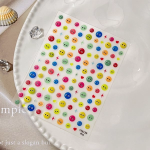 3D embossed cartoon eye nail stickers in various colors on a white ceramic plate