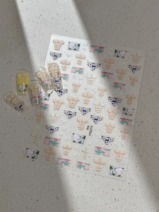 Macro shot of summer nail decals featuring muscle torsos and beach shorts on nail tips