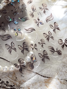 Detailed view of YT6406 nail stickers with iridescent bow and pearl ribbon patterns