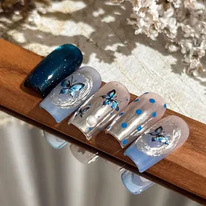 Silver laser blue butterfly press-on nails with 3D embossed patterns and pearl accents