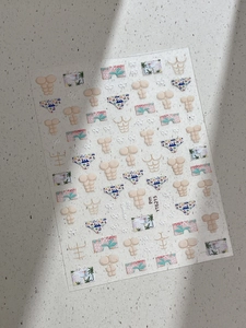 Detail showing summer-themed nail stickers with swimwear and coconut tree patterns