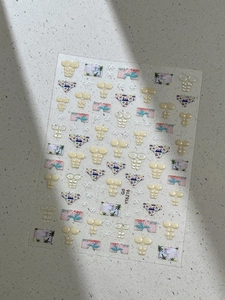 Detail of summer nail stickers featuring beach swimwear patterns and palm trees