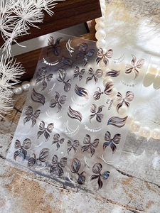 Detail of adhesive butterfly nail art stickers with glitter effects and ribbon designs