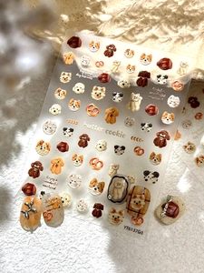 Detail view of cute dog and cookie nail art stickers on a textured background