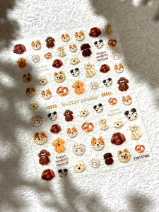 Macro shot of 3D embossed cute puppy and butter cookie nail art stickers on plush fabric