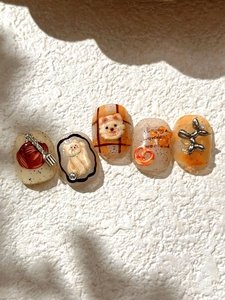 Close-up of 3D embossed nail art patches with cute animal figures and metallic accents