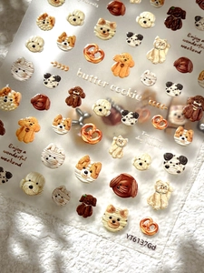 Macro view of 3D butter cookie puppy nail stickers with textured dog head illustrations