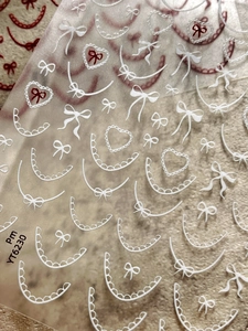 Macro shot of white lace bow and heart patterns on self-adhesive nail art stickers YT6230