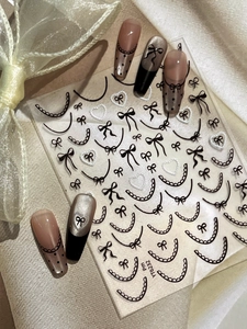 Detailed French style nail stickers featuring black and white lace, bows, and heart patterns