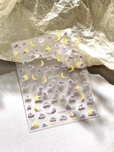 Macro shot of Dreamy Sky nail art sticker with purple clouds and yellow moon stars