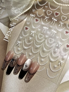Detailed French lace nail art stickers with white bows and red hearts on elegant nails