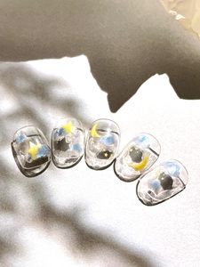 Close-up of cloud and star pattern nail stickers on polished fabric background