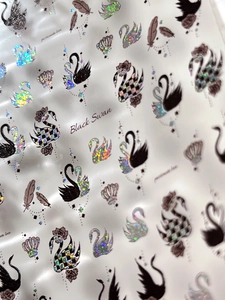 Macro detail of laser swan nail art stickers with glitter feathers and crown patterns