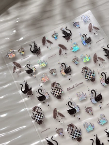 Macro shot of black swan nail art stickers with laser glitter and crown detail patterns