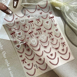 Lace french nail stickers with red bow and white heart patterns on elegant satin backdrop