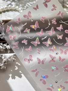 Vue macro de stickers ongles papillon rose 3D avec effet laser et strass scintillants