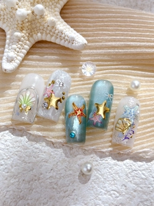 Detailed view of ocean theme press-on nails with 3D seashells, stars and pearls