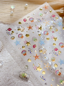 Detail of 3D embossed sea shell nail stickers with gold gradient starfish and coral designs