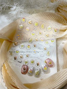 Detail of silver floral nail stickers with roses and daisies on soft pink false nails