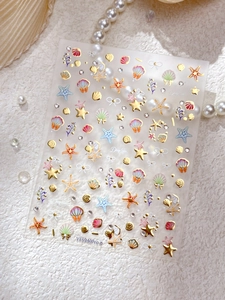 Detail of gold-embossed deep sea nail art stickers with shells and starfish designs