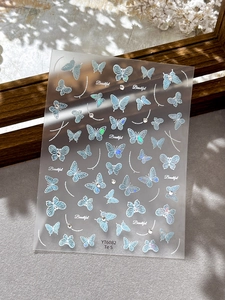 Gros plan d'autocollants pour ongles papillon irisés avec finition laser holographique