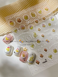 Macro detail of 3D embossed floral nail stickers with silver foil outlines on nails