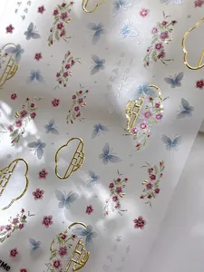 Detail view of bronzing butterfly nail stickers with delicate gold edges and floral art