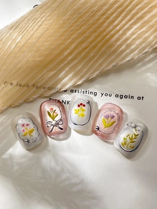 Detailed close-up of handmade press-on nails with silver flowers and pearl accents