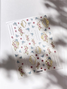 Detail of gold butterfly nail stickers with floral patterns and Chinese window frames