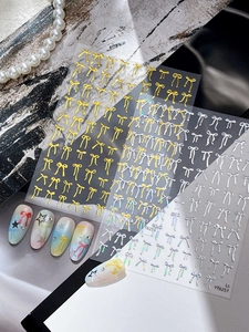 Detailed view of 3D embossed bow nail stickers with gold and silver metallic finish