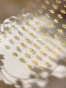 Detailed view of Chinese auspicious cloud nail art stickers with gold outlines and colorful motifs