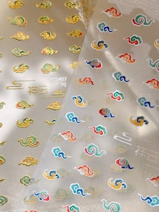 Macro detail of Chinese auspicious cloud nail stickers with gold outlines and color prints