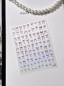 Close-up of 3D laser bow nail stickers with holographic metallic texture and 3D effects
