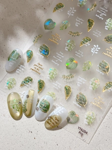 Detailed macro view of tropical leaf nail stickers with golden iridescent accents on nails