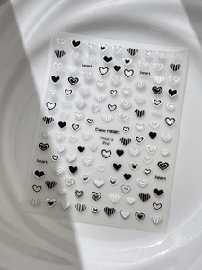 Détail des stickers à ongles cœur sur un plateau en céramique avec jeux de lumière