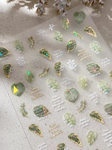 Macro detail of tropical leaf nail stickers with gold foil and gradient green patterns