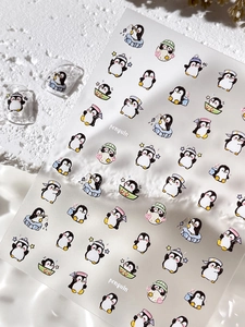 Gros plan de stickers à ongles 3D pingouin avec divers motifs de dessins animés mignons