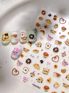 Détail d'autocollants à ongles pain cartoon avec motifs toast et donut sur faux ongles